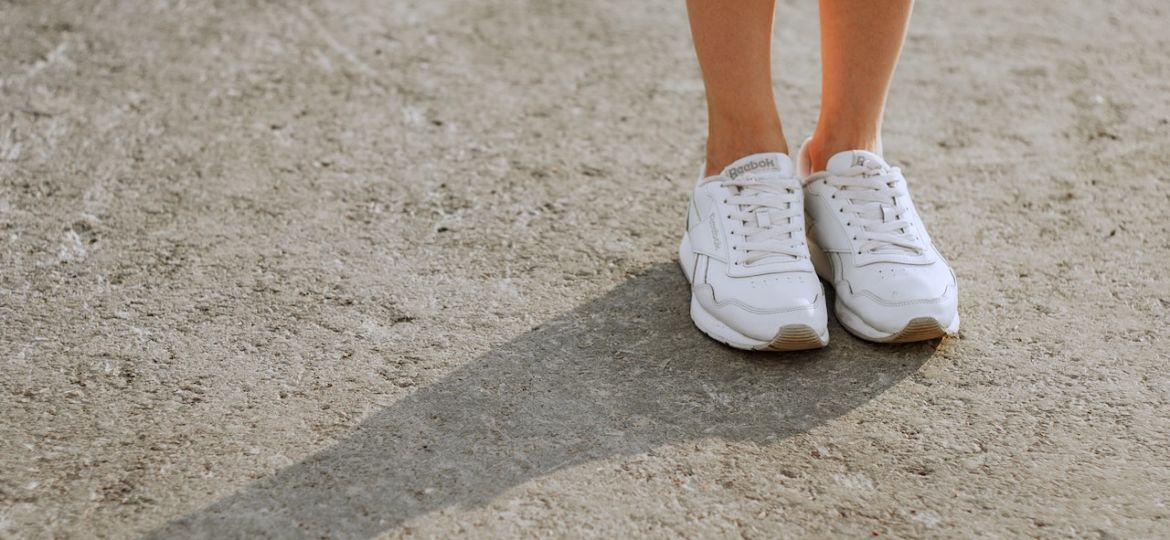 girl in a green skirt standing in white sneakers